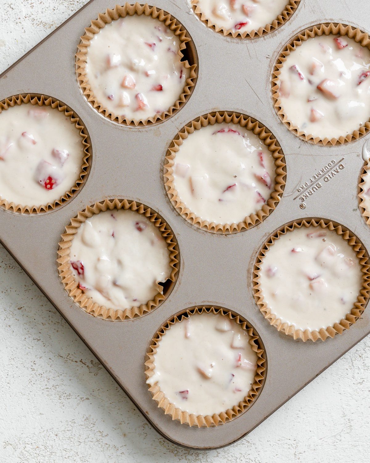 process shot showing added batter to muffin tin