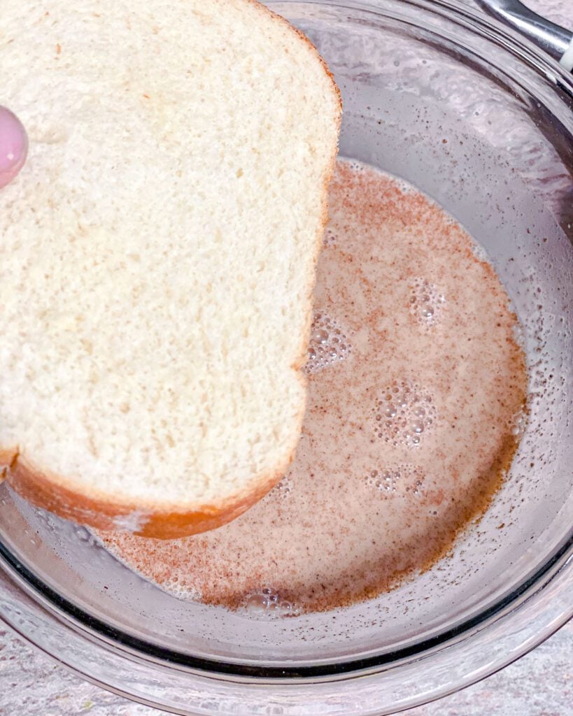 process shot of adding bread to french toast mixture