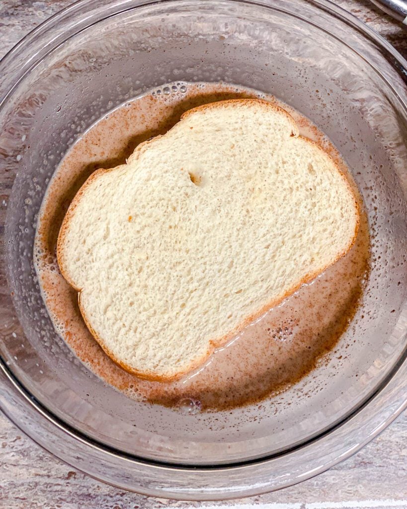 process shot of soaking bread in french toast mixture