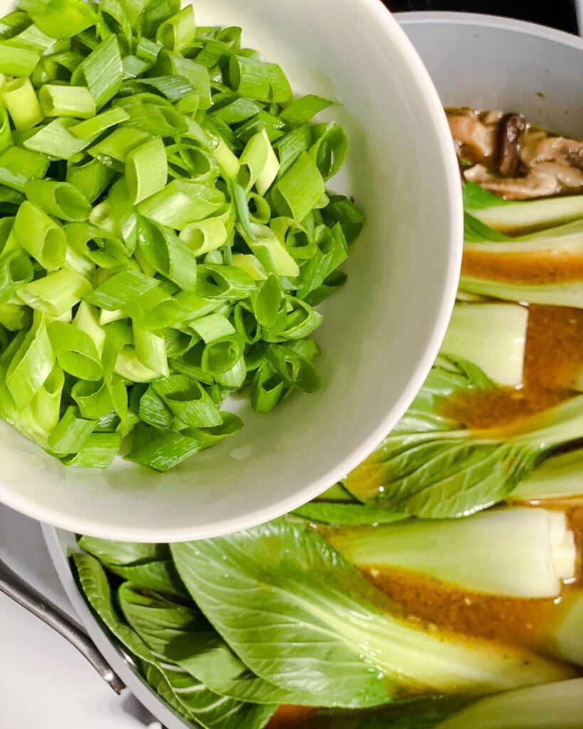 process shot of adding green onions to pan