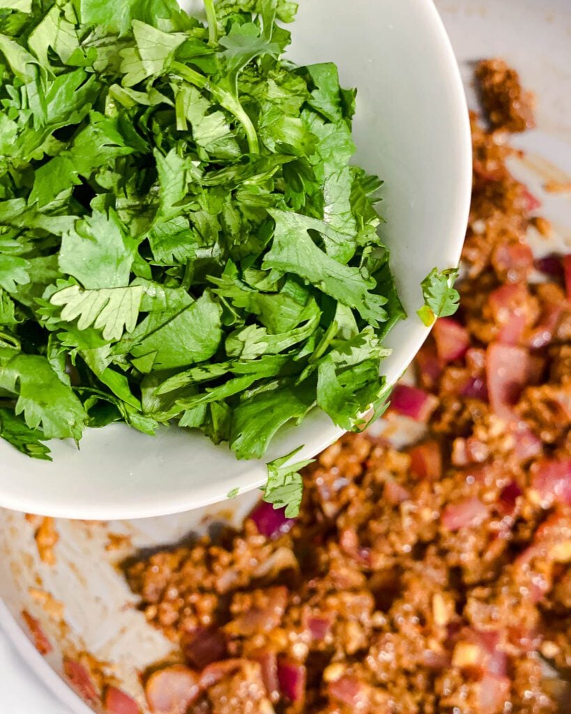 process shot of adding cilantro to pan