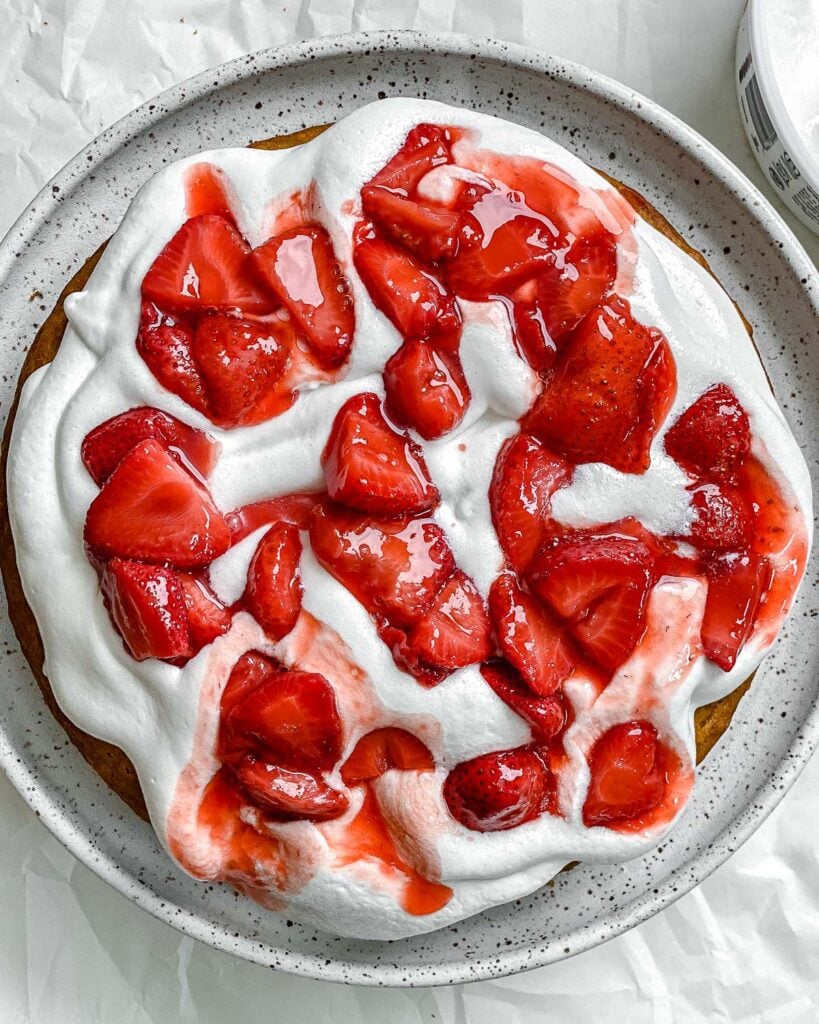 sliced strawberries on top of topping and baked cake
