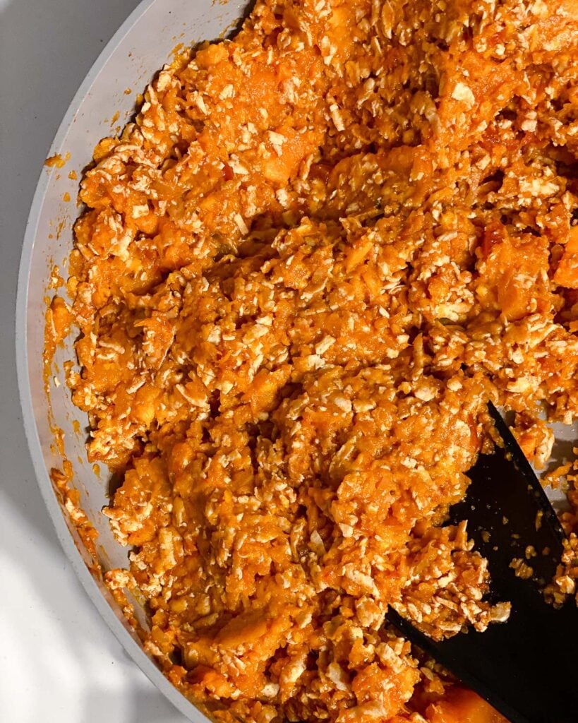 process shot of mixing sweet potatoes and tofu mixture together in pan