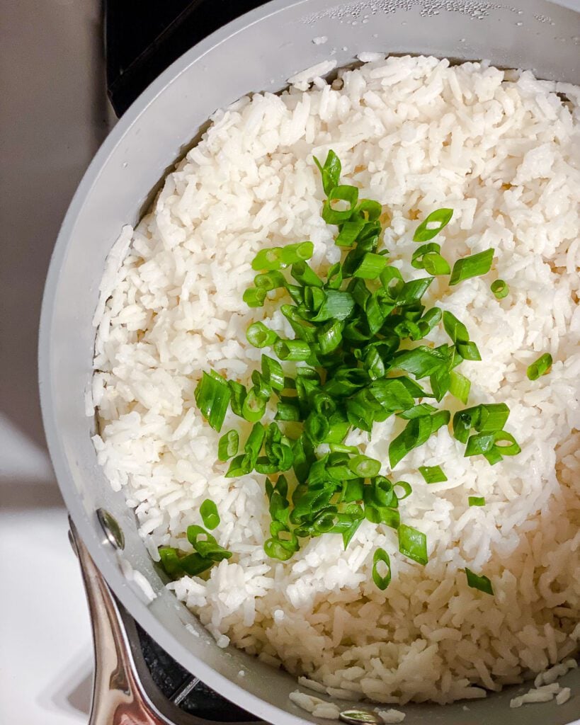 process shot showing added green onions to rice in pot