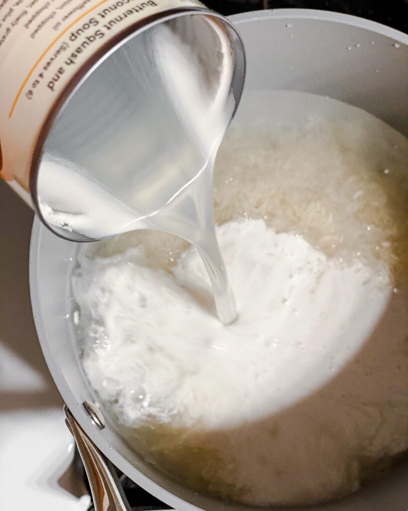 process shot of adding coconut milk to pot of rice