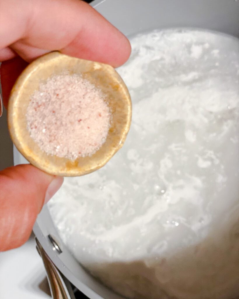 process shot of adding salt to pot of rice
