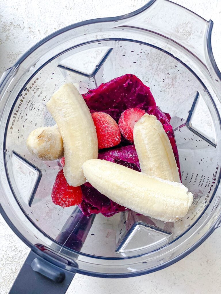process shot of adding Dragon Fruit Smoothie Bowl (Pitaya Bowl) to blender
