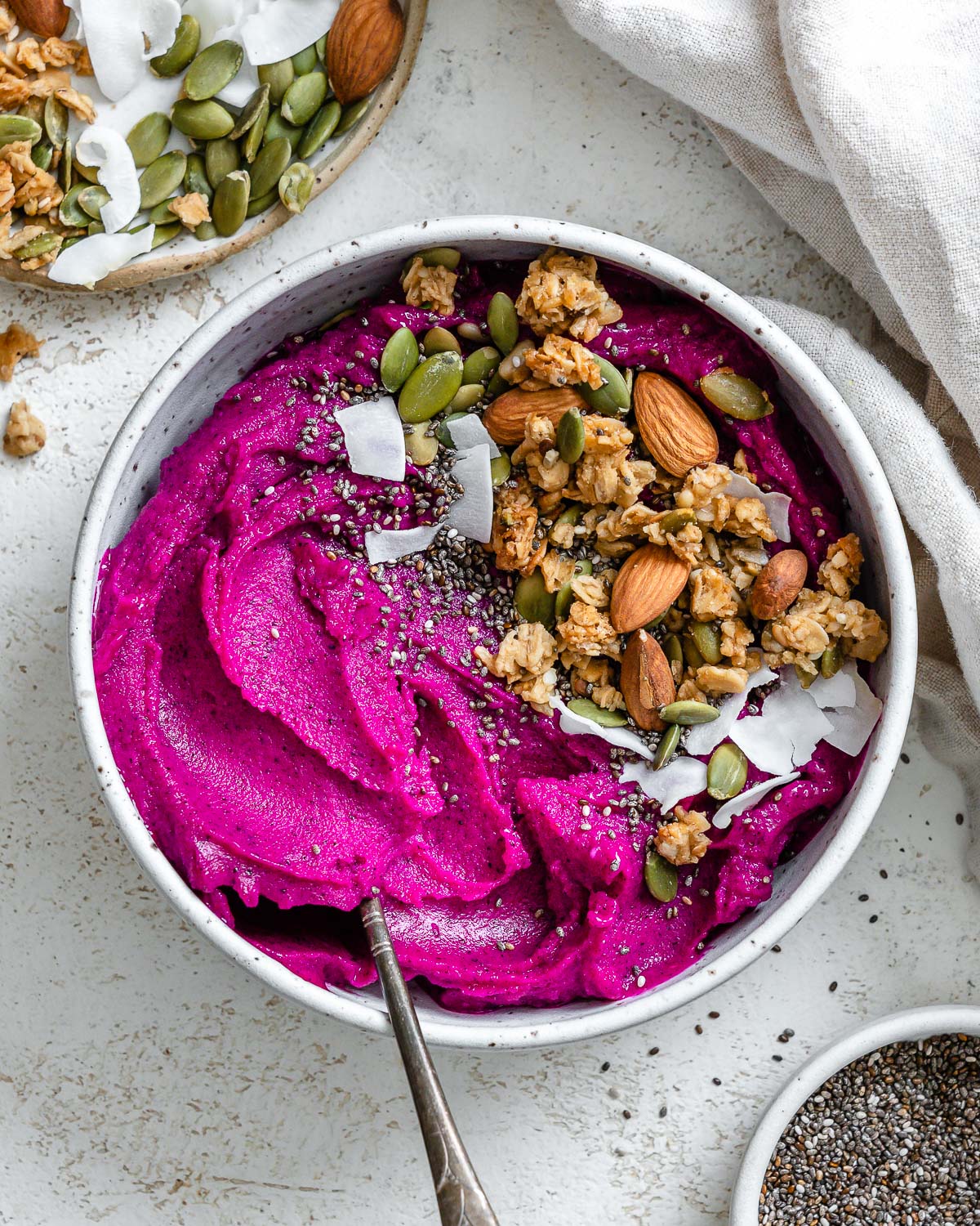 completed Dragon Fruit Smoothie Bowl (Pitaya Bowl) in a bowl against a light surface