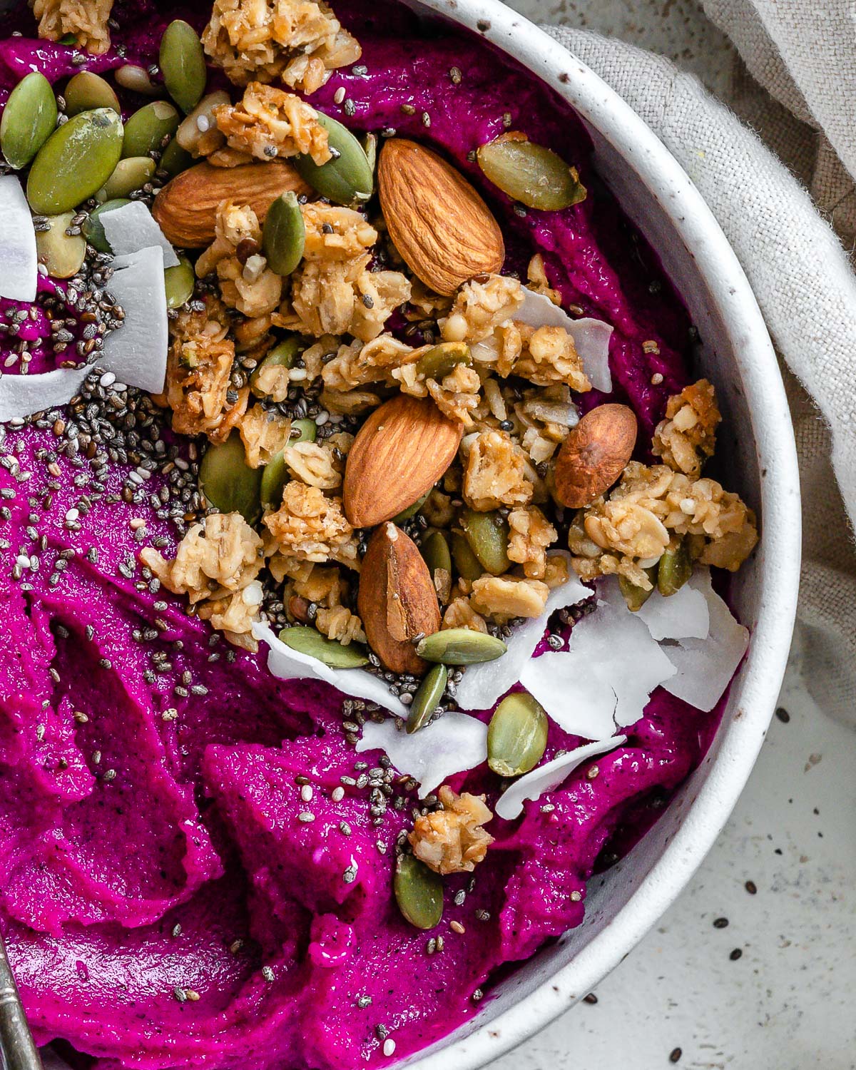 completed Dragon Fruit Smoothie Bowl (Pitaya Bowl) in a bowl against a light surface