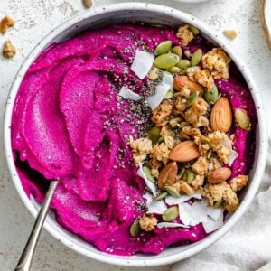 completed Dragon Fruit Smoothie Bowl (Pitaya Bowl) in a bowl against a light surface
