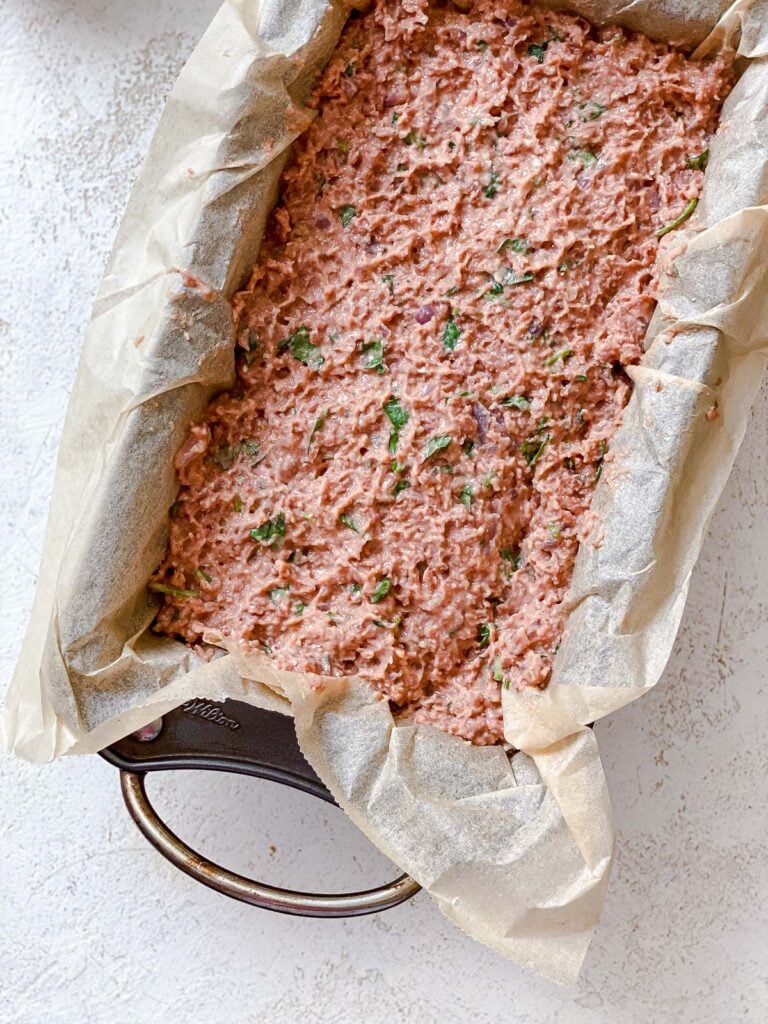 process shot showing the addition of meatloaf mixture in loaf pan