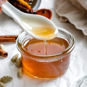 completed Cardamom Syrup in a jar with a spoonful showing consistency