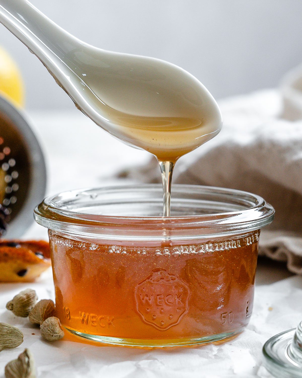 completed Cardamom Syrup in a jar with a spoonful showing consistency