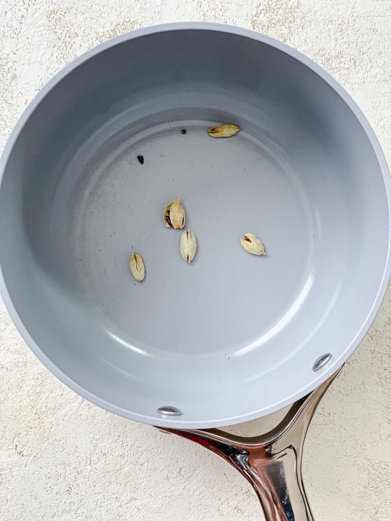 process shot of adding cardamom pods to pot