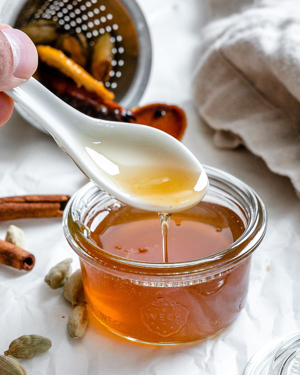 completed Cardamom Syrup in a jar with a spoonful showing consistency