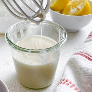 process shot showing lemon glaze falling from whisk in glass container