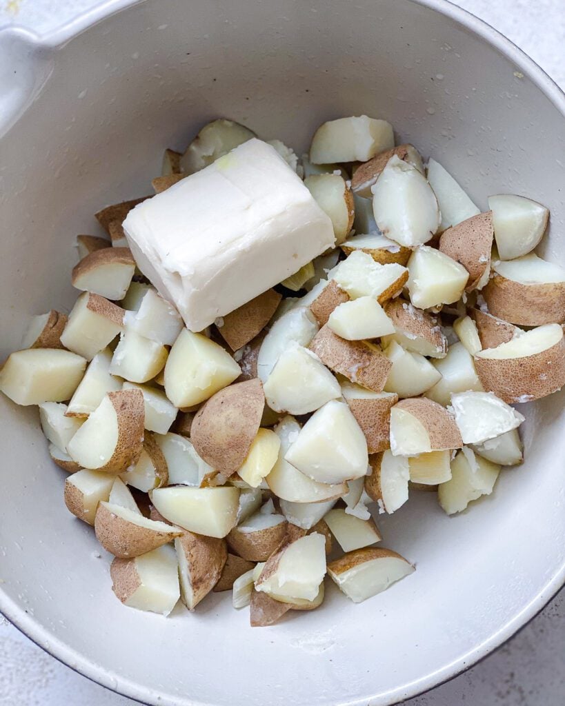 process shot showing plant butter added to pot of potatoes