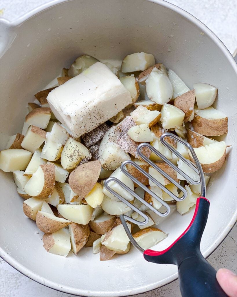 process shot showing the beginning of mashing potatoes in bowl