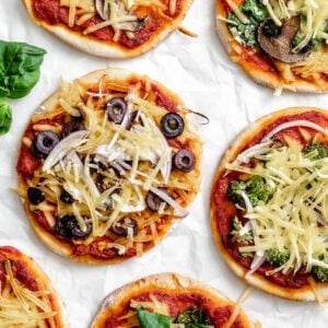several completed Flatbread Mini Pizzas on a white surface