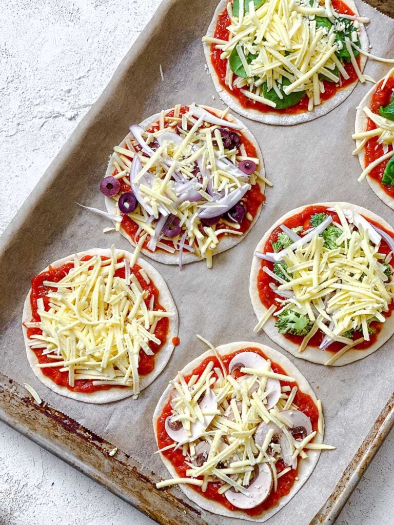 toppings added to dough on baking sheet