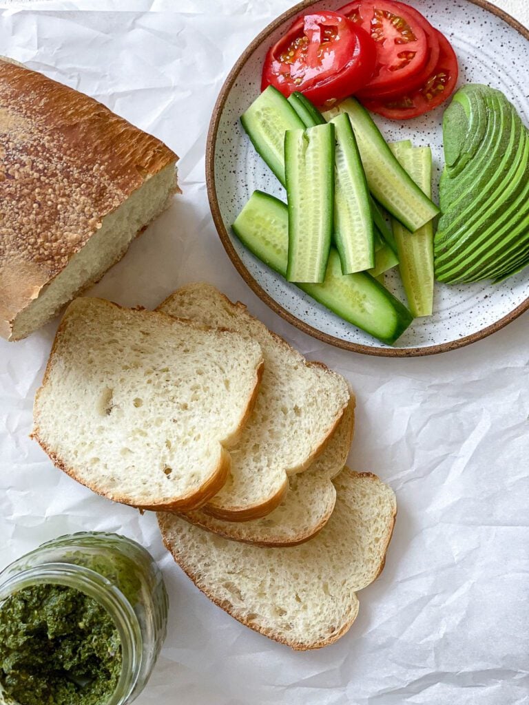sliced bread and sliced ingredients against a white surface