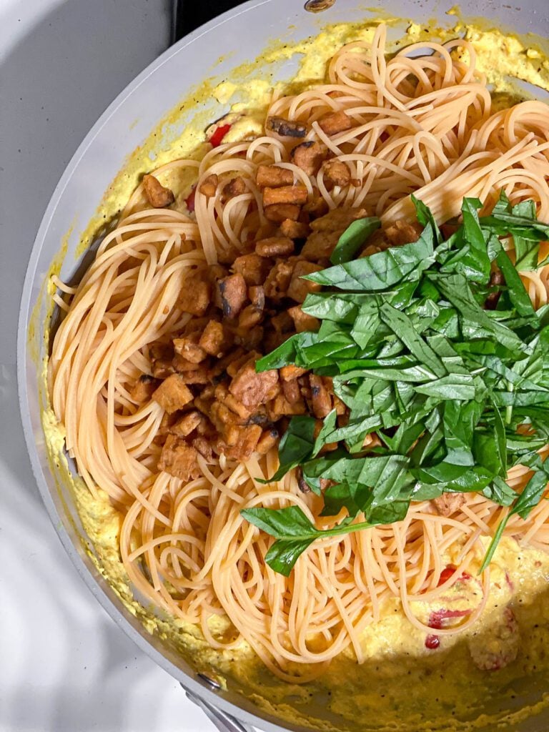 process shot showing the addition of basil to pan