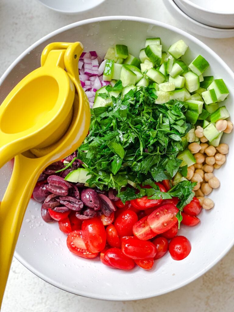 process shot showing juicing a lemon onto salad