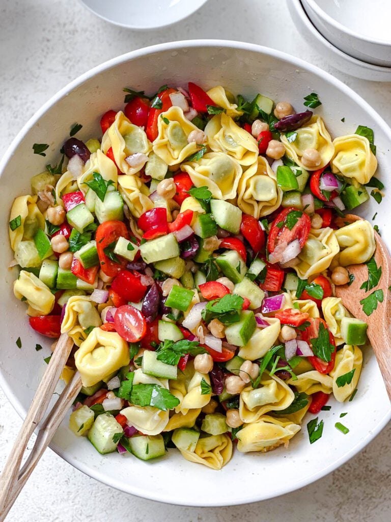 process shot of mixing ingredients for Tortellini Pasta Salad in bowl