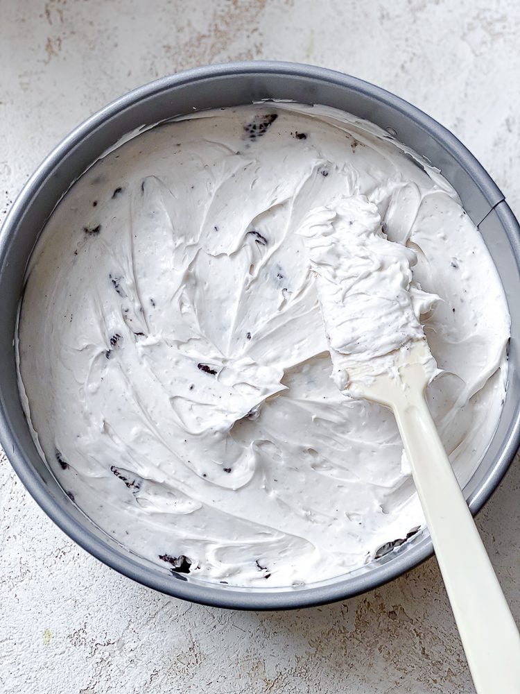 process shot of leveling vegan cream cheese mixture on crust
