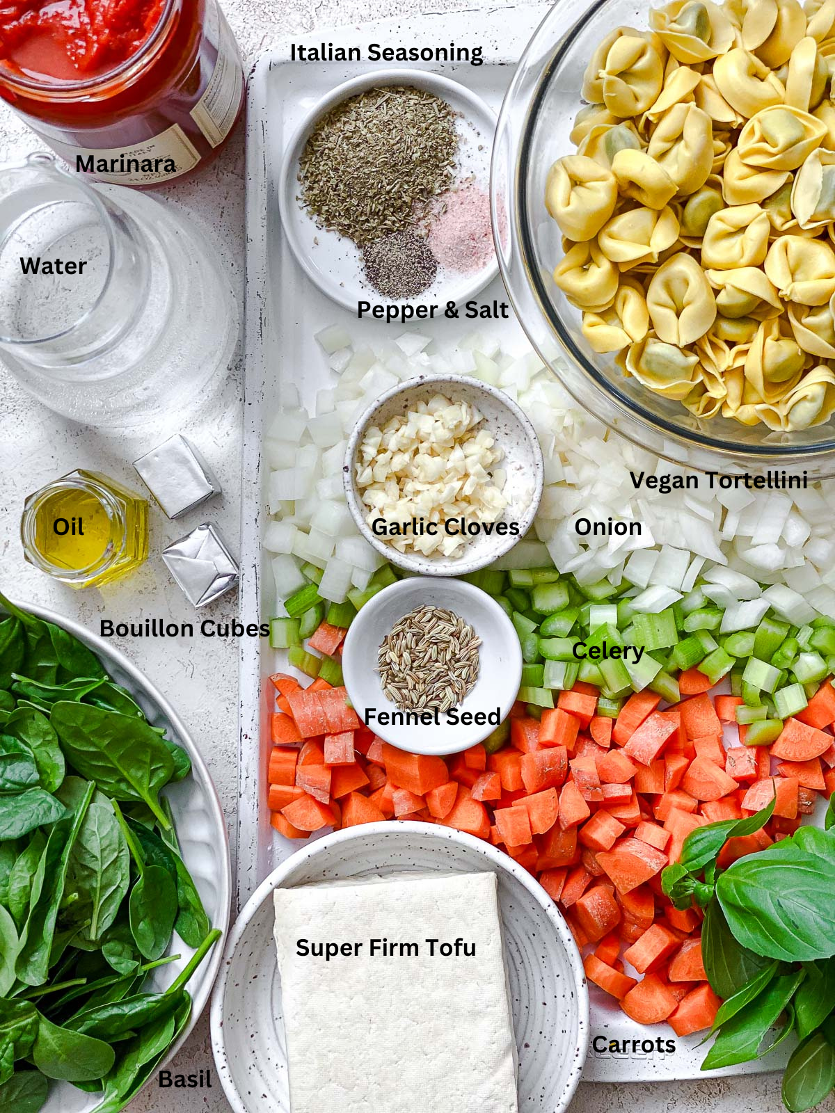 ingredients for Vegan Tortellini Soup measured on a white surface