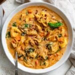 completed Vegan Tortellini Soup in a bowl on a white surface