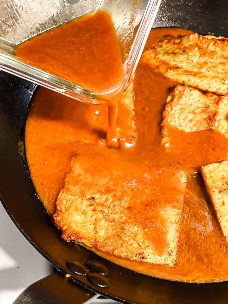 process shot of marinade being added to skillet