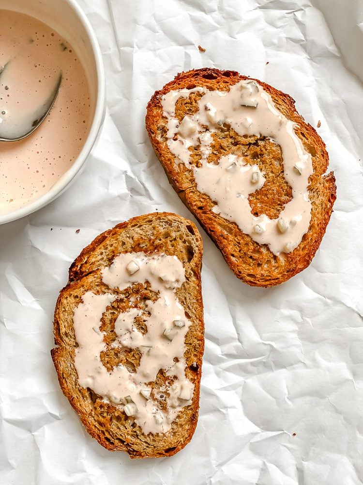 process shot showing buttered bread alongside bowl of sauce