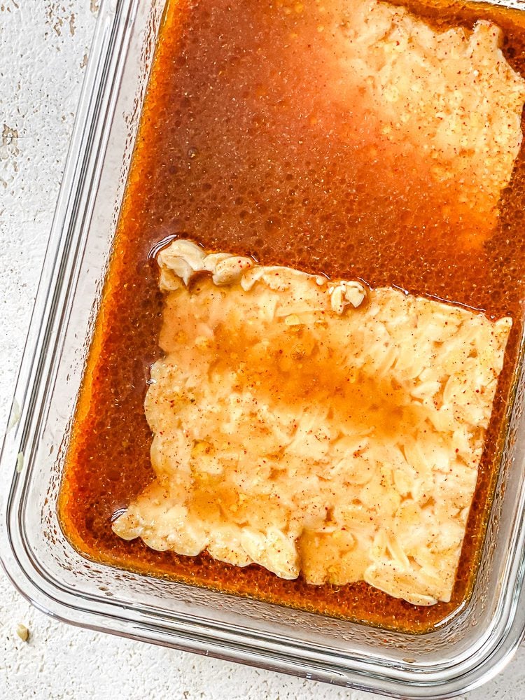 process shot of tempeh marinating in tupperware