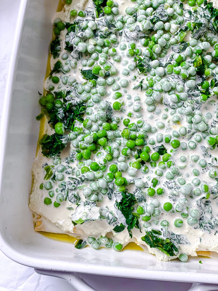 process shot showing vegan alfredo sauce being added to dish