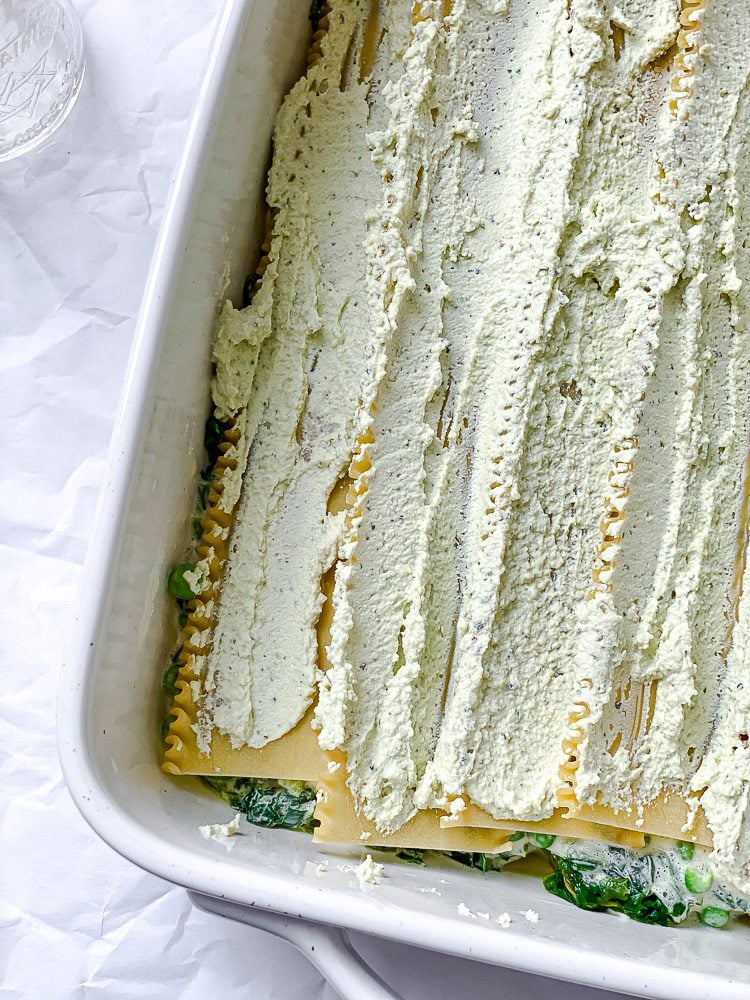 process shot showing tofu ricotta being added to dish