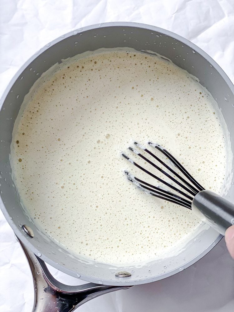 process shot of ingredients being whisked in pan