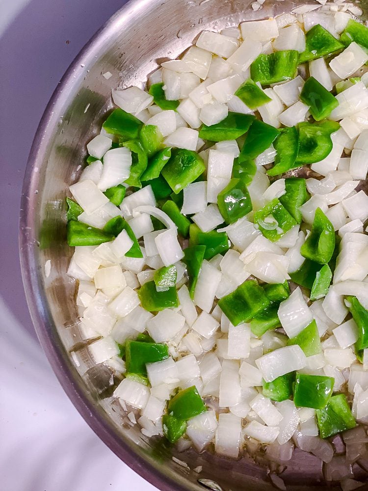 process shot of veggies cooking in pan
