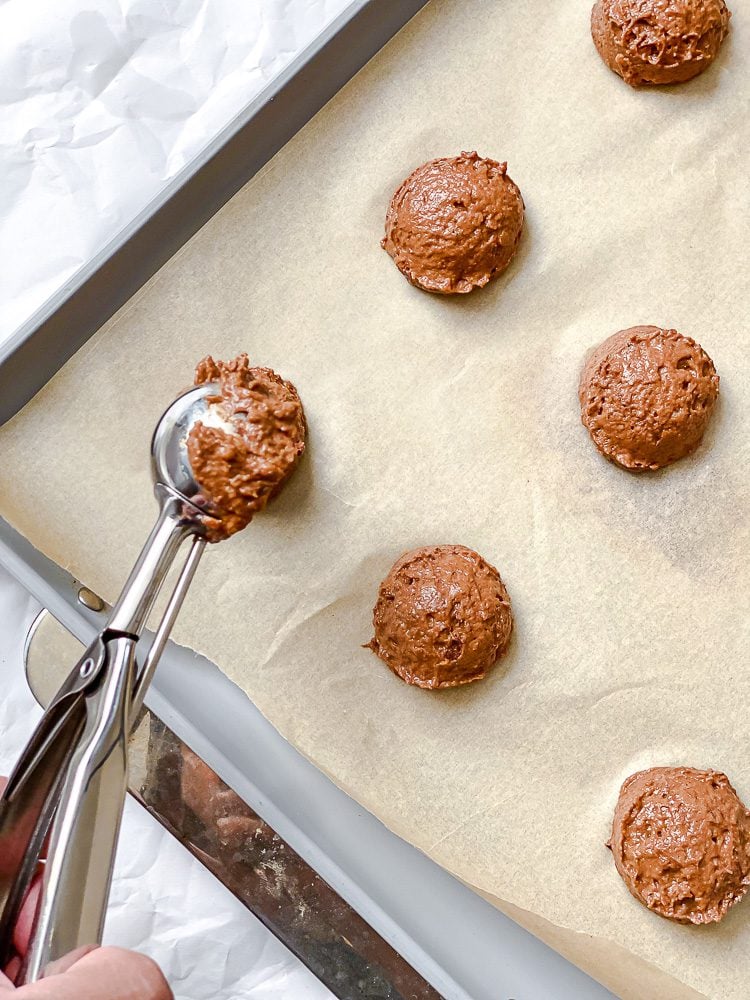 process shot showing scooping cookie batter onto baking sheet