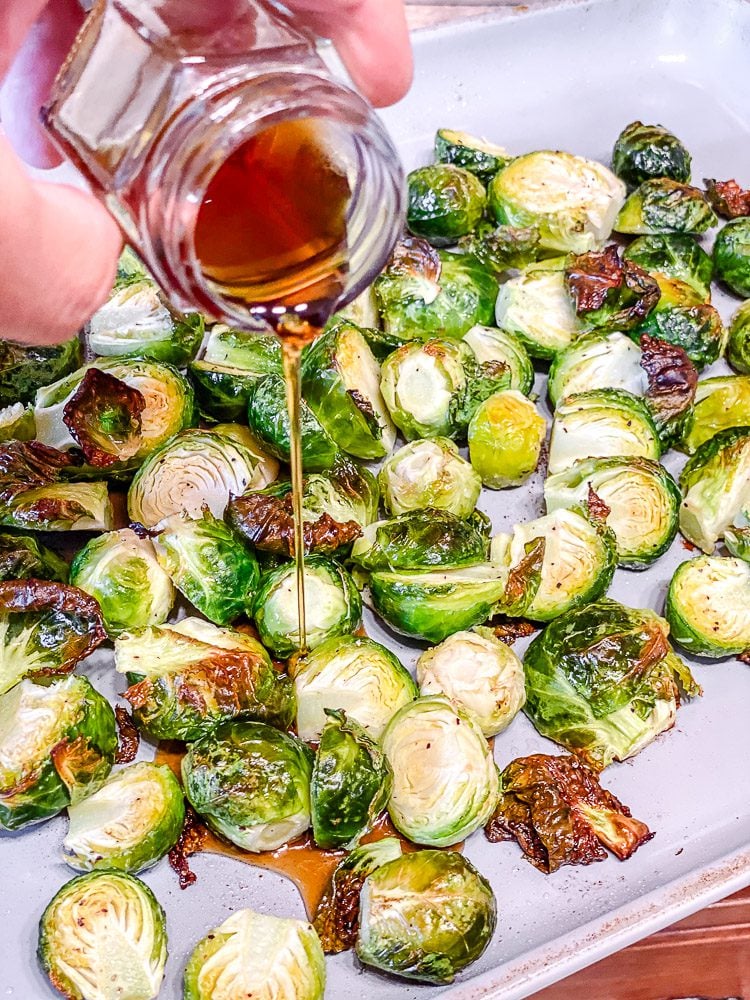 process shot showing adding maple syrup to brussels sprouts