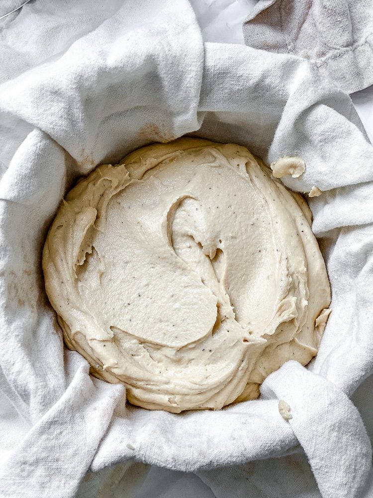 process shot showing vegan cheese ball in a bowl in a towel