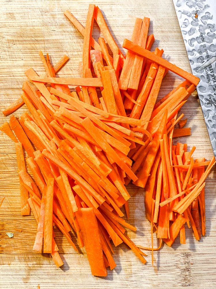 process shot showing julienned carrots on cutting board