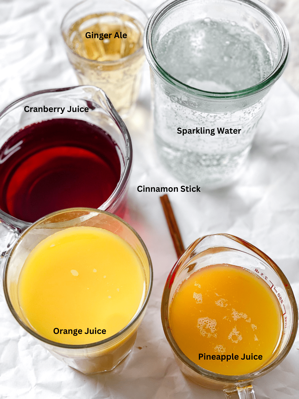 ingredients for Non Alcoholic Christmas Punch measured out on a white surface