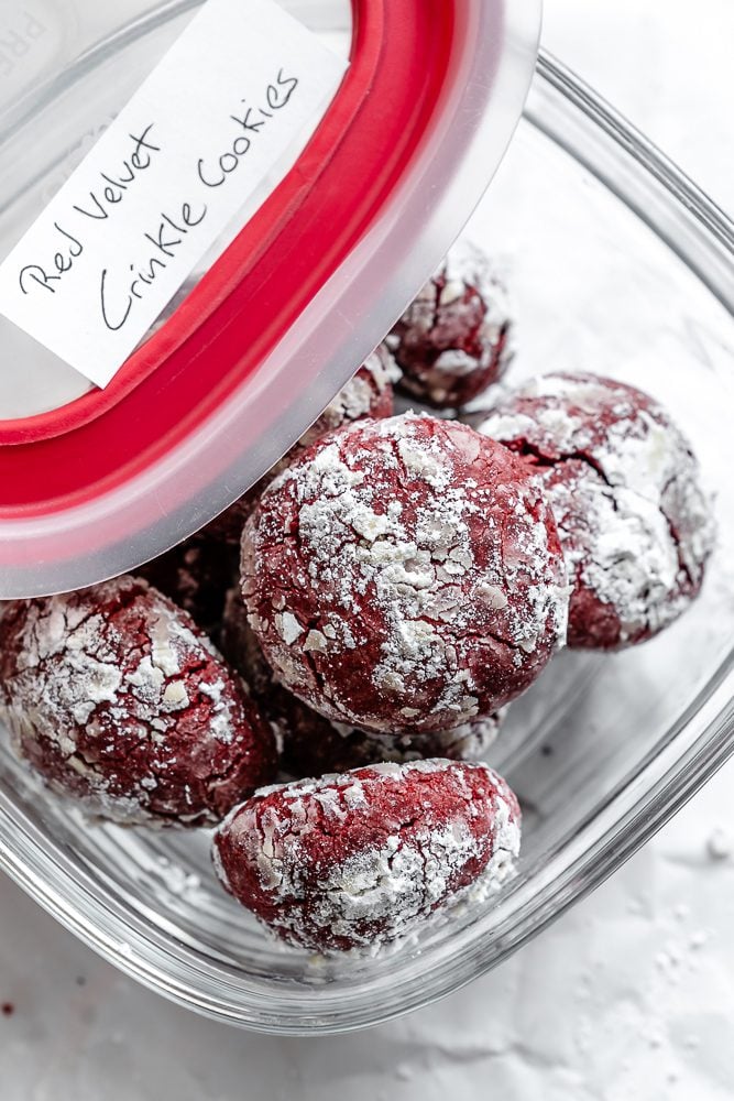 completed Red Velvet Crinkle Cookies in a storage container