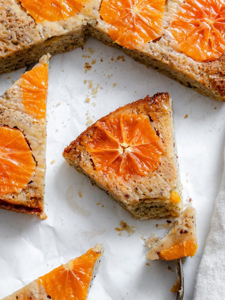 completed Orange Upside Down Cake on a white surface in slices