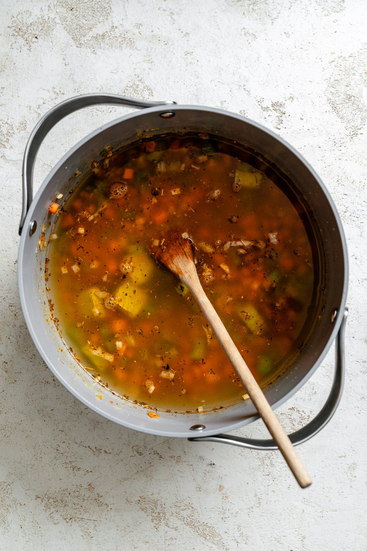 Process shot showing stirring ingredients in a pot.