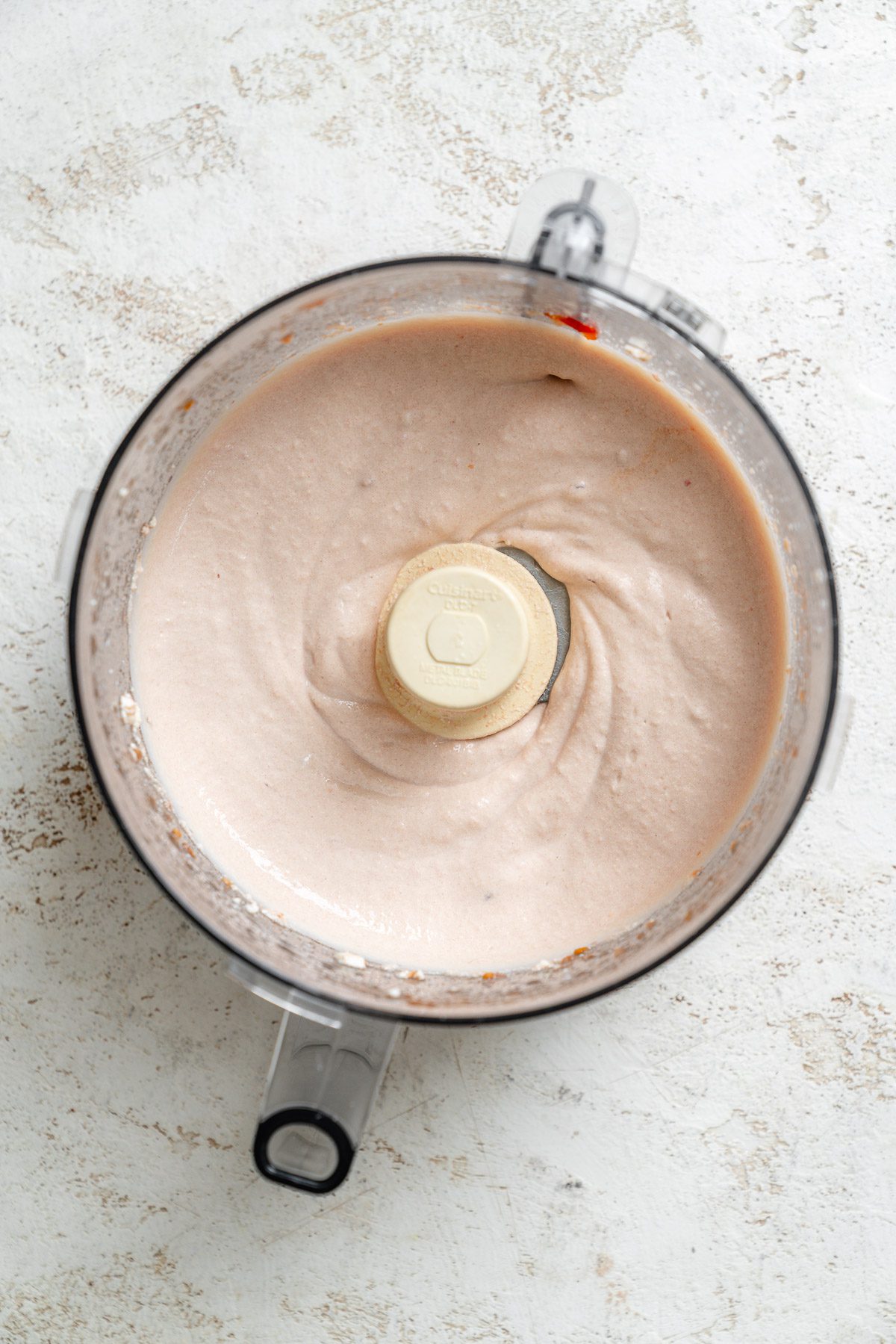 Process shot showing vegan cream in food processor.