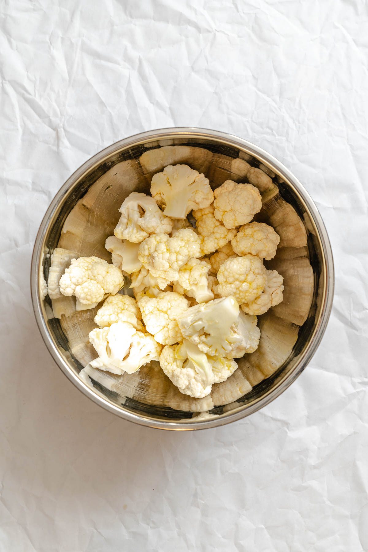 Process shot showing cauliflower in a bowl.