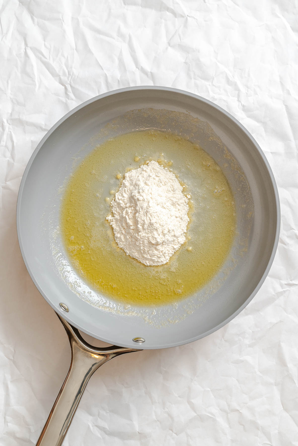 Process shot showing melted vegan butter and flour in a pan.