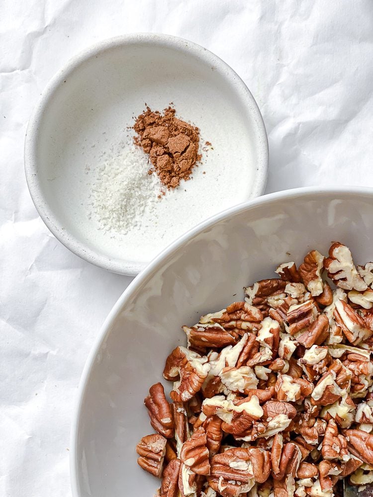 Process shot showing nut mixture ingredients in a bowl alongside spices.